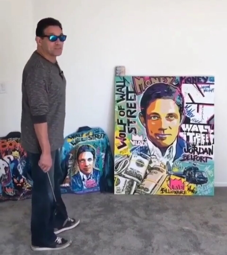 Джордан Белфорт поруч з картиною Wolf of Wall Street
